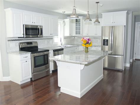 stainless steel appliances in a kitchen with white cabinets|white kitchen with stainless steel countertops.